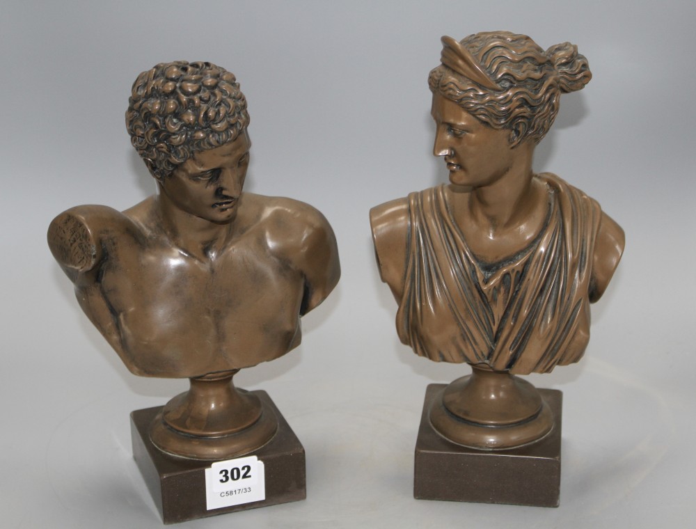 A pair of bronzed resin busts of Diana and Apollo, on integral bases, height 30cm